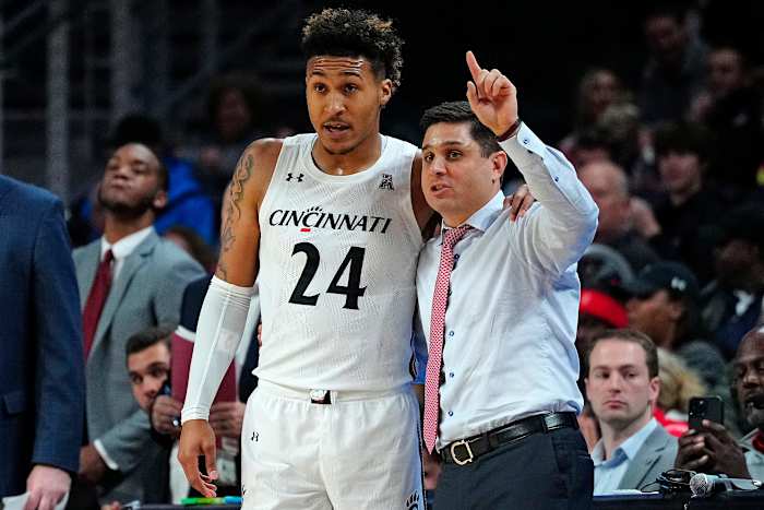 Cincinnati Bearcats guard Jeremiah Davenport (24) takes notes from head coach Wes Miller in the first half of the NCAA basketball game between the Cincinnati Bearcats and the Eastern Kentucky Colonels at Fifth Third Arena in Cincinnati on Sunday, Nov. 13, 2022. Eastern Kentucky Colonels At Cincinnati Bearcats Basketball